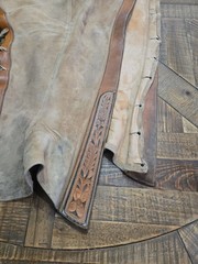 vintage western chaps feature a hand-tooled floral motif on the yoke
